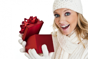 Frau mit Geschenk, Weihnachtsgeschenk, Belohnung, Mitarbeiter, Weihnachten, strahlendes Lächeln, Mütze, Handschuhe, Schal