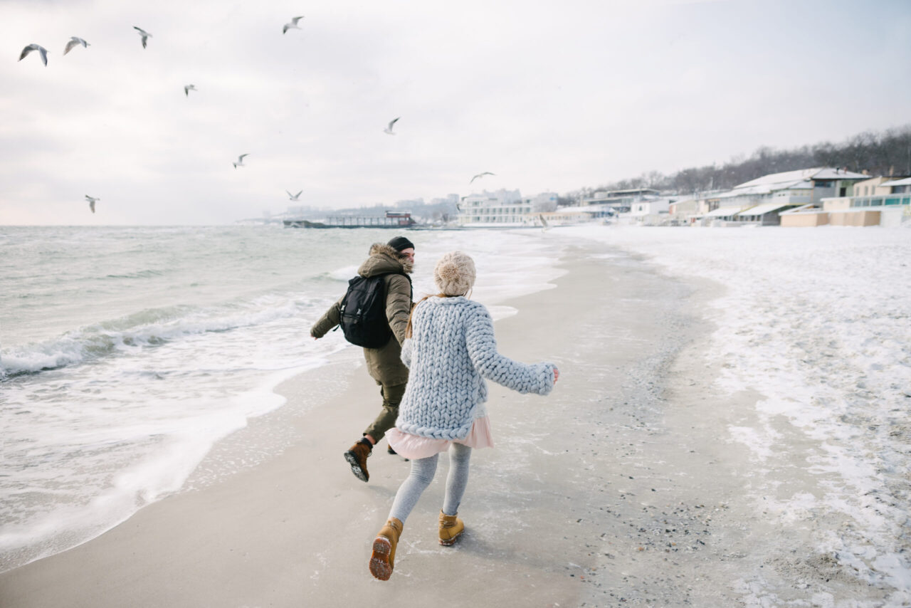 Betriebliches Gesundheitsmanagement: Zwei Personen laufen am Meer entlang