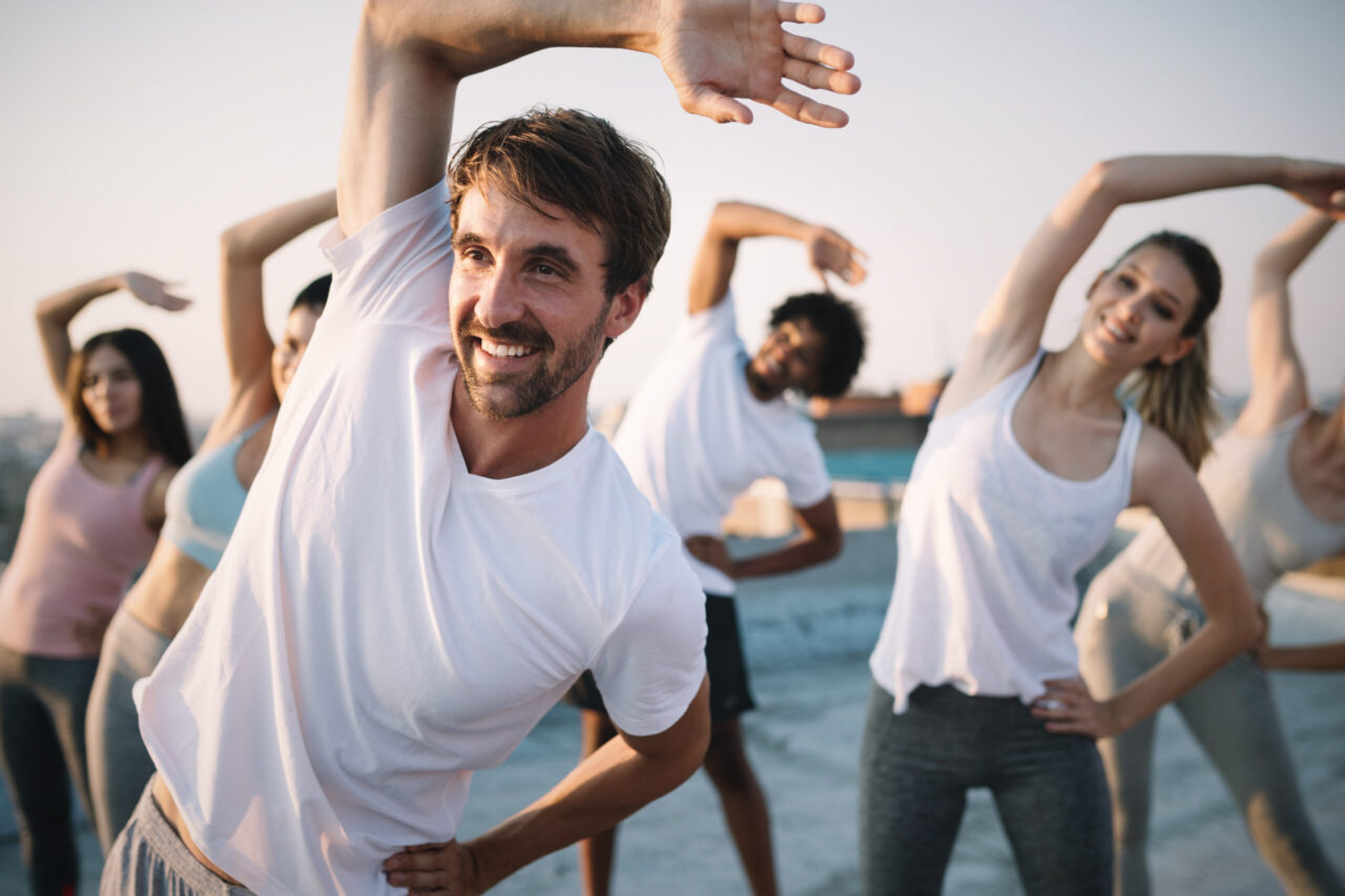 Betriebliches Gesundheitsmanagement: Kollegen machen gemeinsam Dehnübungen