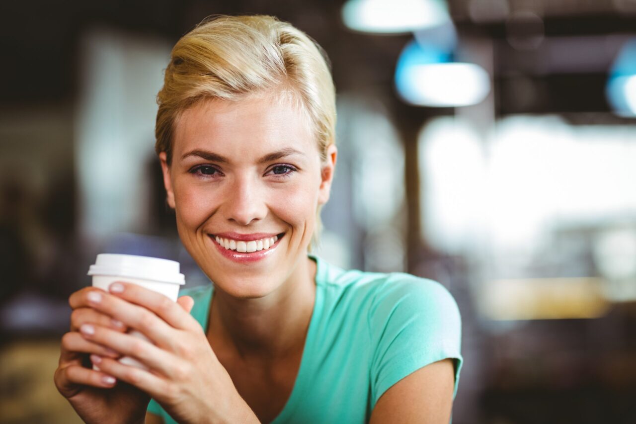blonde Frau mit einem Kaffeebecher