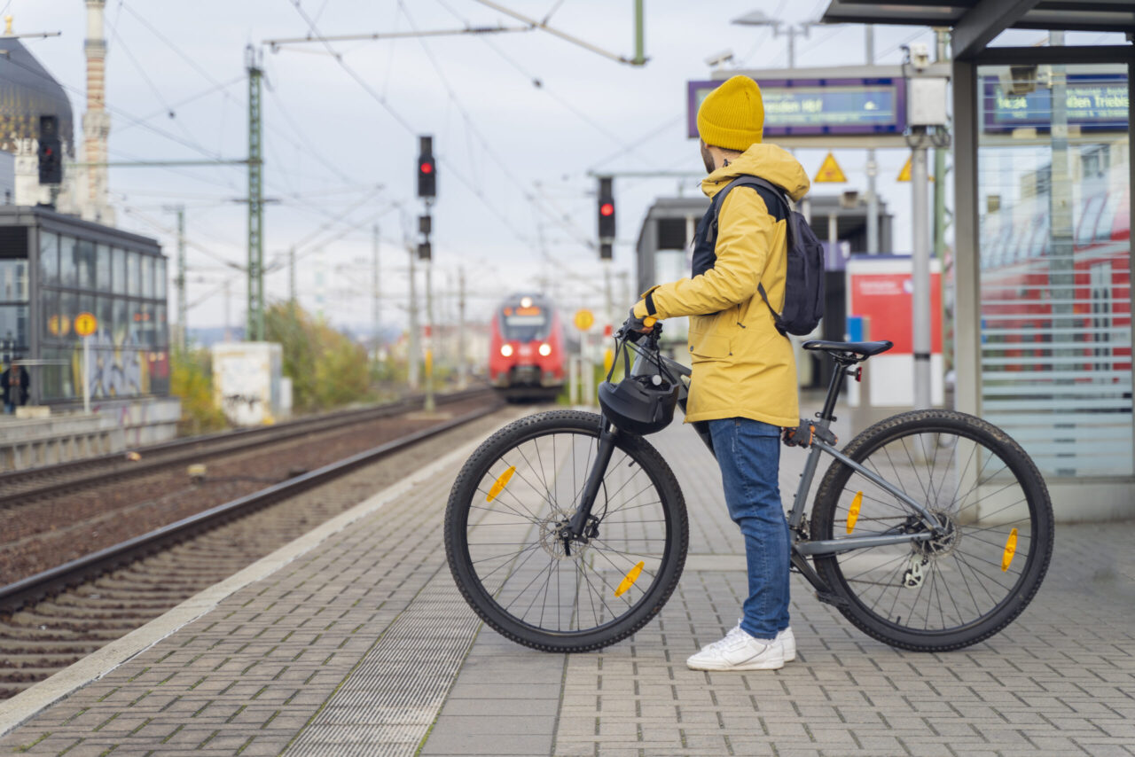 Jobrad Leasing: Ein Mann in Winterkleidung, der mit seinem Fahrrad auf den Zug wartet.