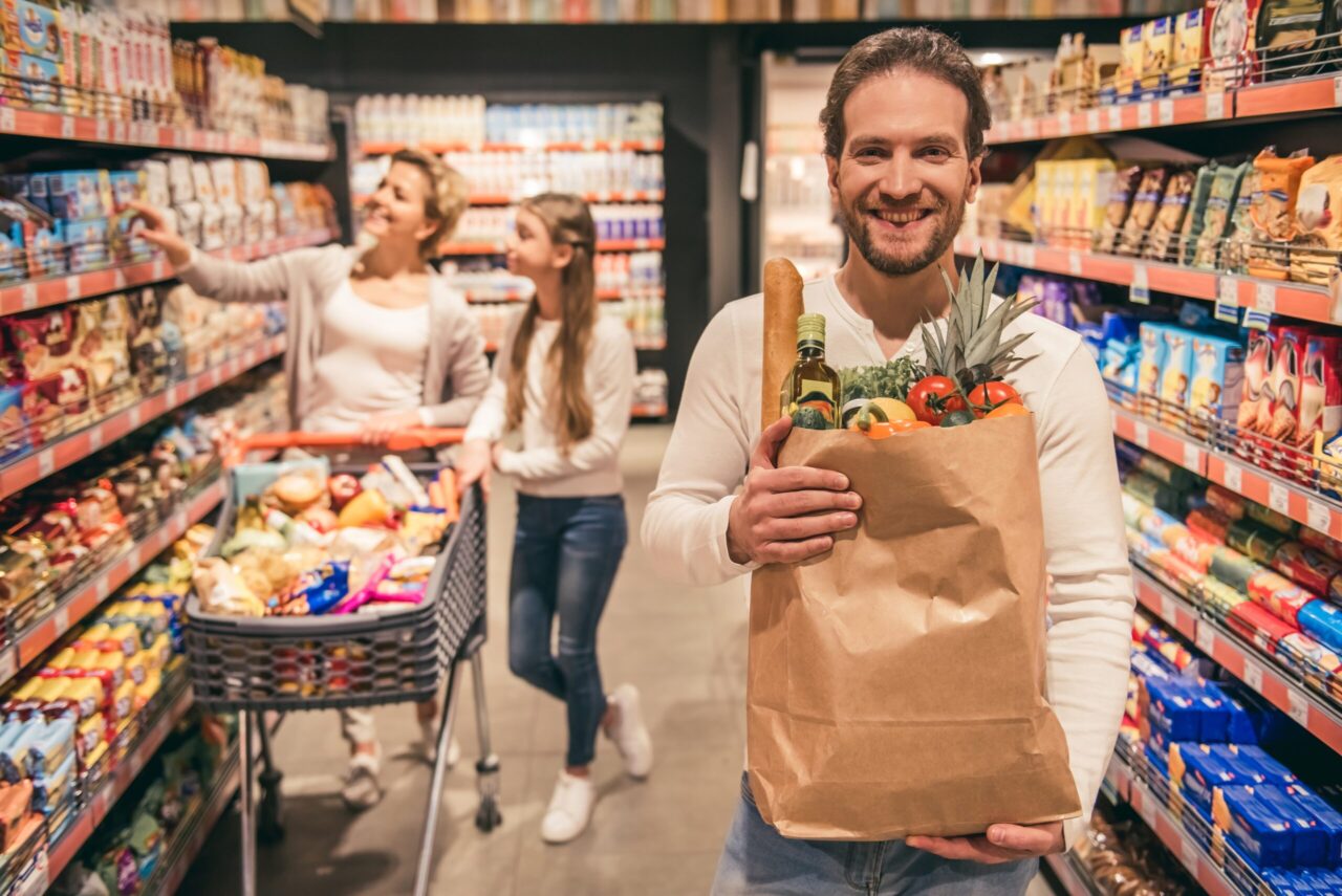 Essenszuschuss: Mann im Supermarkt mit einer Einkaufstüte