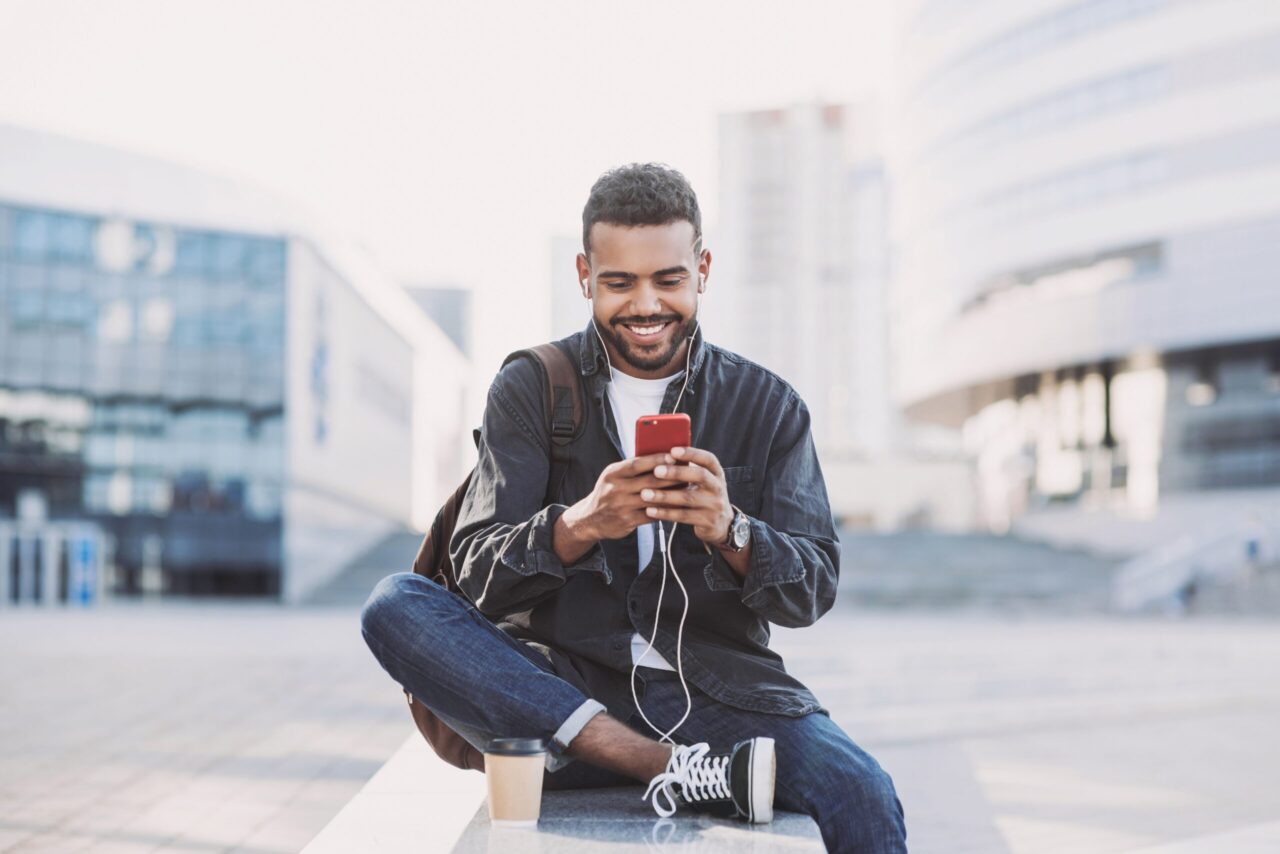 Internetpauschale: Mann sitzt in der Stadt und arbeitet am Handy