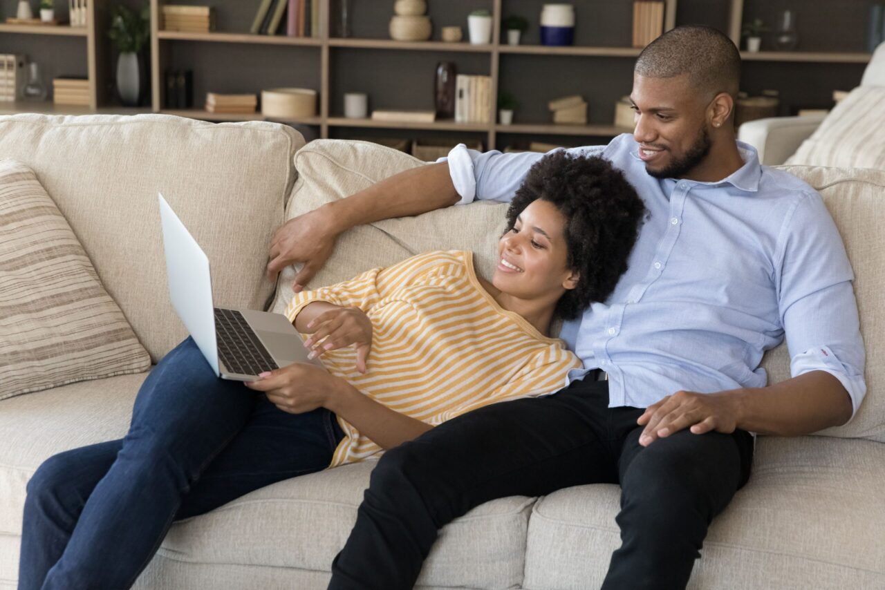 Personalrabatt: Frau und Mann sitzen auf der Couch und schauen auf einen Laptop